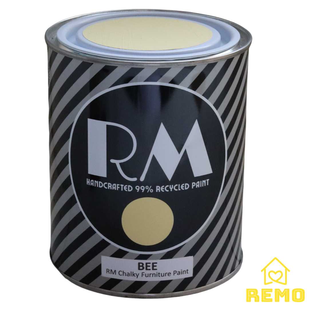 Angled front view of an RM Paint tin in the colour BEE. Shows the painted stickers on the front and the top of the tin lids.